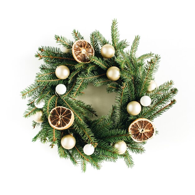 Christmas wreath frame made of fir branches decorated with dried oranges and Christmas balls.  top view