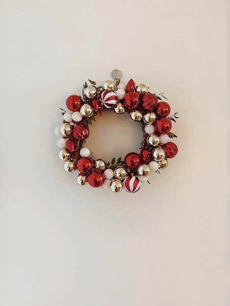 사진 흰색 바탕에 빨간색과 금색 크리스마스 공으로 만든 크리스마스 화환 프레임