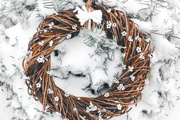 枝からのクリスマスリース。雪の中でドアに手作りの花輪。冬の装飾