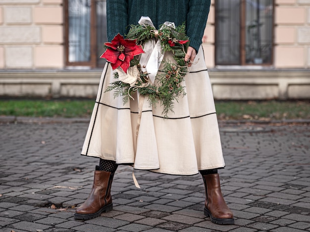 スタイリッシュな女性の街歩きの手にクリスマスリース