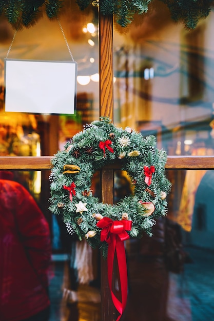 Ghirlanda di natale sulla porta di legno di vetro del negozio decorazione di natale o capodanno