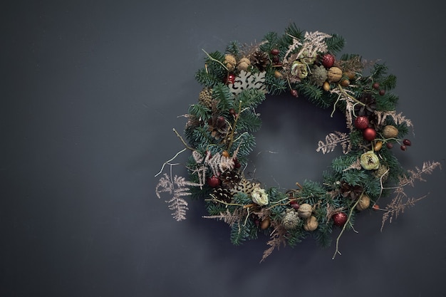 Christmas wreath of vines decorated with fir branches, Christmas balls and natural materials,  