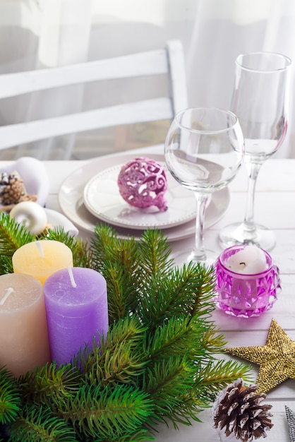 Christmas wreath with colorful big candles on a table