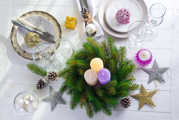 テーブルにカラフルな大きなろうそくとクリスマスの花輪