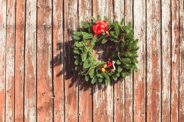 Christmas wreath with decorations on the shabby wooden door.