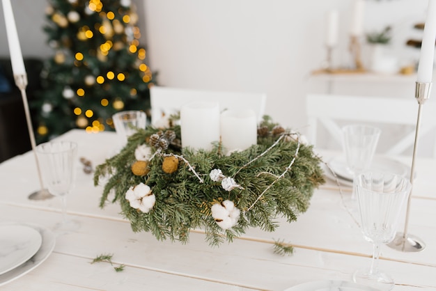 Photo christmas wreath with white candles on the festive table