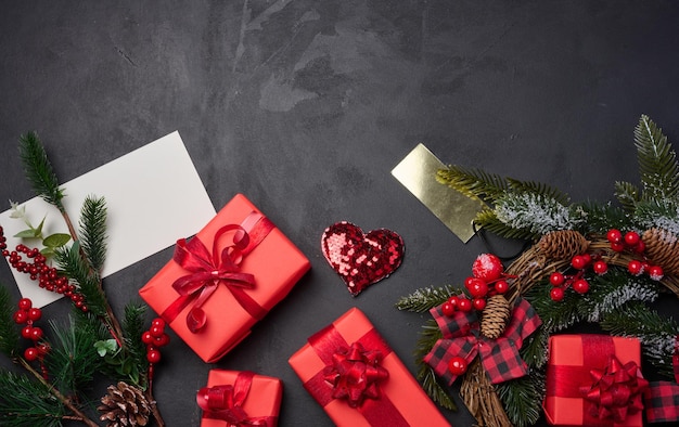 Christmas wreaths fir branches and gifts on a black background View from above Copy space