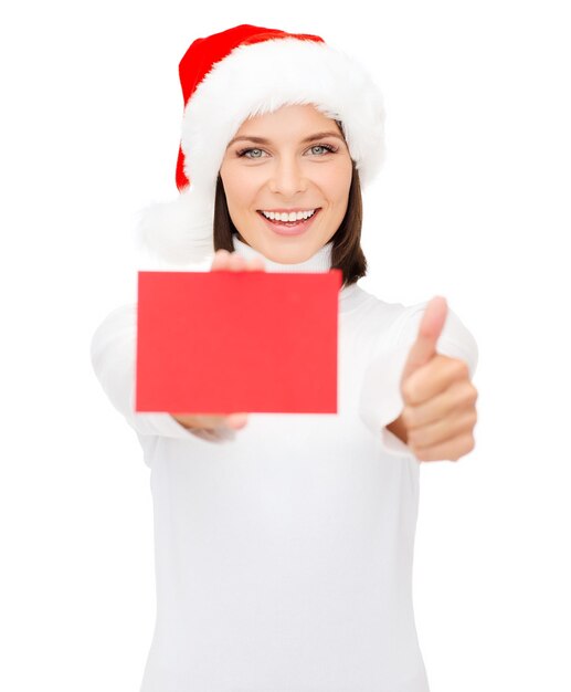 christmas, x-mas, people, advertisement, sale concept - happy woman in santa helper hat with blank red card showing thumbs up