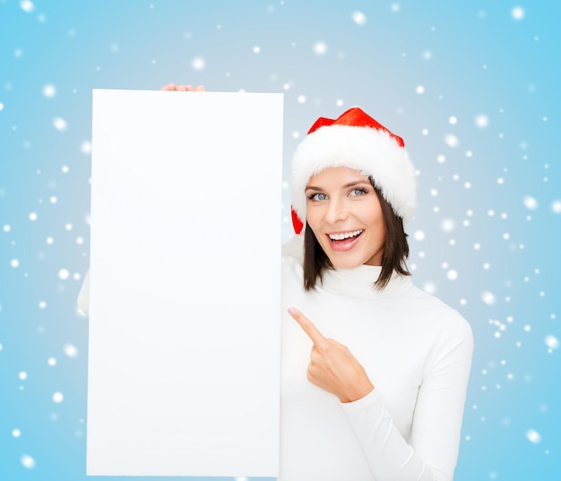 christmas, x-mas, people, advertisement, sale concept - happy woman in santa helper hat with blank white board