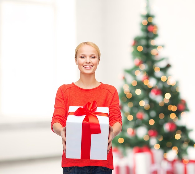 クリスマス、クリスマス、バレンタインデー、お祝いのコンセプト-ギフトボックスと赤いセーターで笑顔の女性