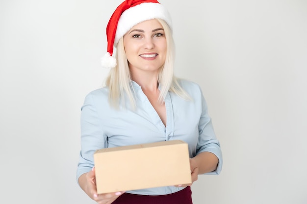 Natale, natale, inverno, concetto di felicità - donna sorridente in cappello dell'assistente di babbo natale con cassetta dei pacchi