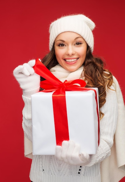 christmas, x-mas, winter, happiness concept - smiling woman in white clothes with gift box