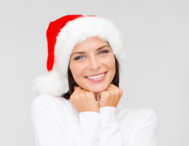 christmas, xmas, winter, happiness concept - smiling woman in santa helper hat