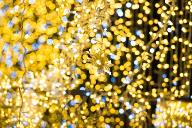 クリスマスの休日の背景のための花輪のクリスマス黄色のライト