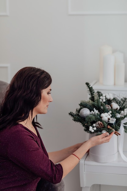 Christmas Young girl touches the New Years bouquet  Makeup Healthy hair style Happy new year