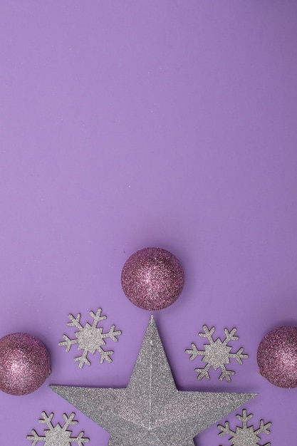 Christmass flatlay christmas tree toys and silver star decor on purple background.