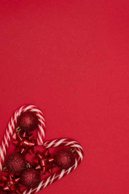 크리스마스의 평평한 심장에는 크리스마스 막대 사탕이 줄지어 있고 크리스마스 트리 장난감으로 장식되어 있습니다.
