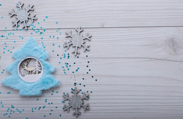 Christmass flatlay kerstboom met blauwe vacht en zilverachtige sneeuwvlokken.