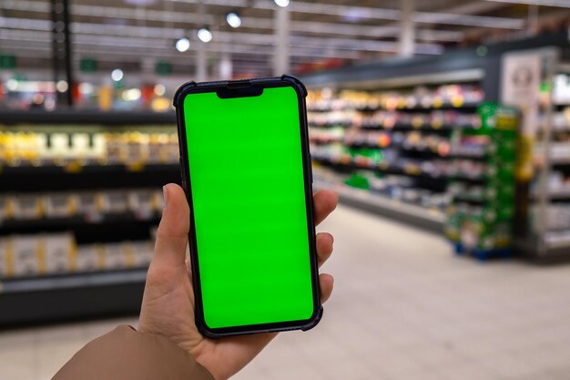 Chroma key Close up of woman hand holds smart phone vertical with green screen at shopping mall store Shopping center Department store Shopping online Gadgets template