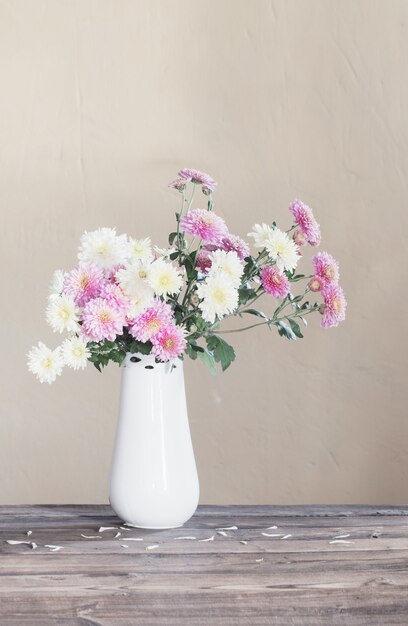 Chrysanten in vaas op oude houten tafel