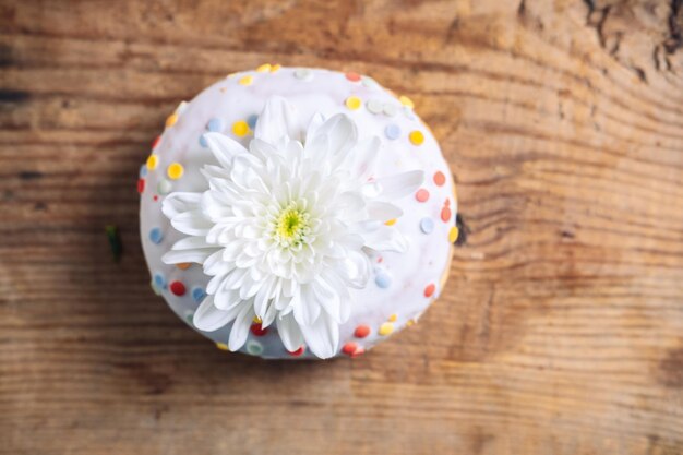 chrysanthemum bud on top of donut on wooden background Delicate frame with white flower