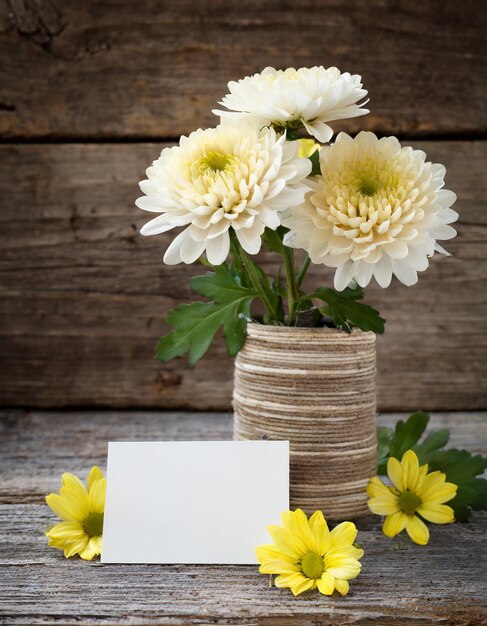 Foto fiore di crisantemo con carta bianca su sfondo di legno invecchiato