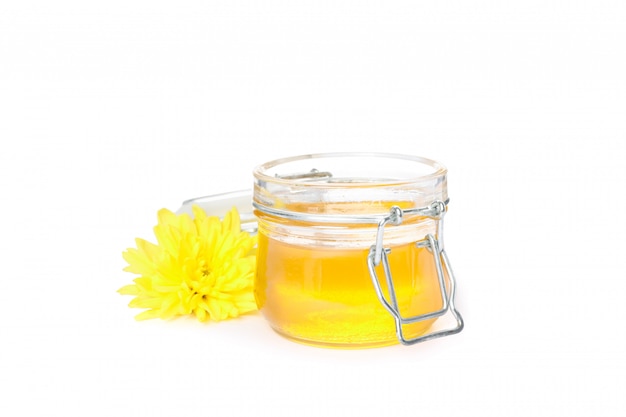 Chrysanthemum and glass jar with honey isolated on white