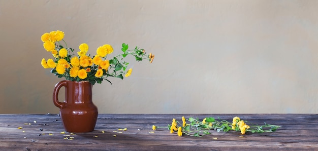 Chrysanthemums in vase on old wooden table