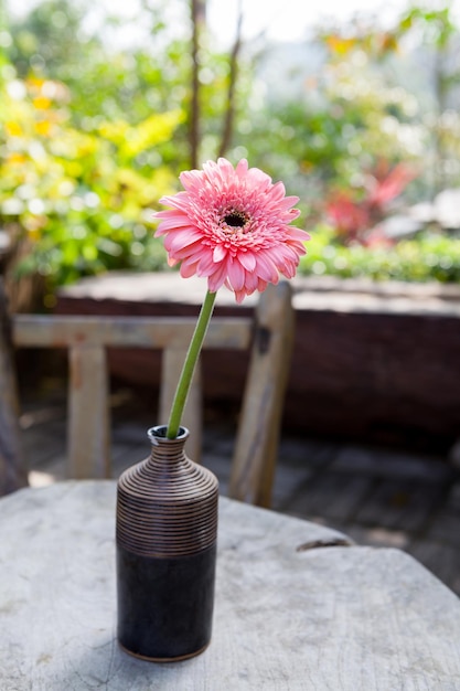 木製のテーブルの上に花瓶の菊