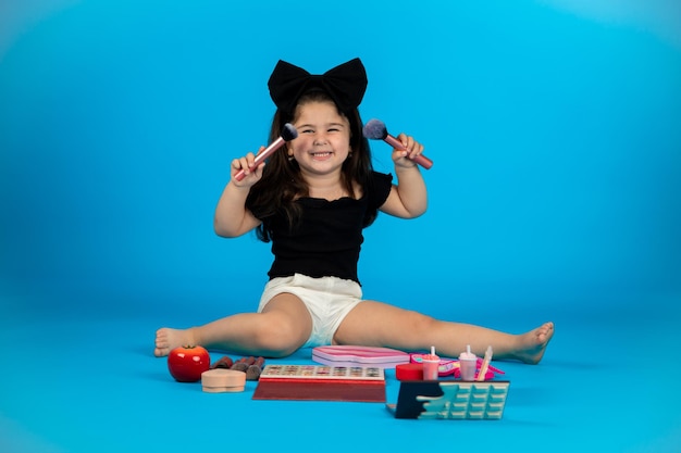 The chubby little happy girl is naughty in the studio and poses in different poses