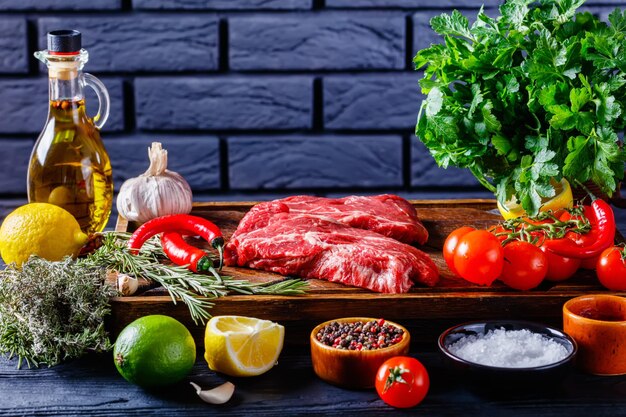 Chuck eye beef steaks on wooden board