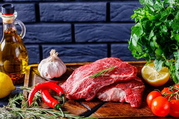 Chuck eye beef steaks on wooden board