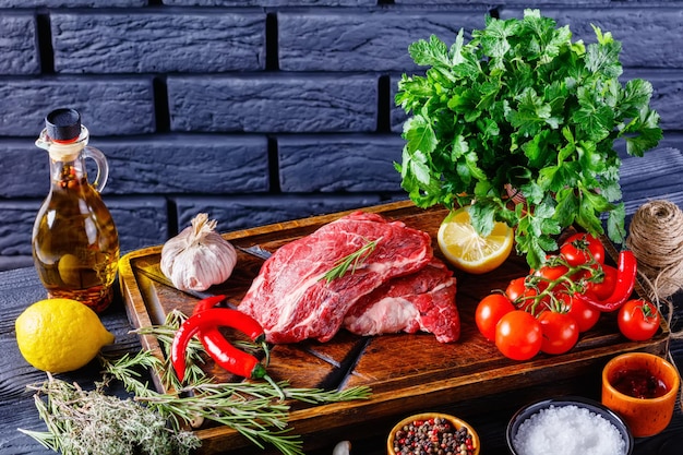 Chuck eye beef steaks on wooden board