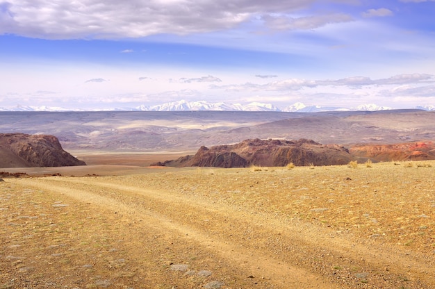 Chui Valley in the Altai Mountains Rocky cliffs car tracks on the plain against t