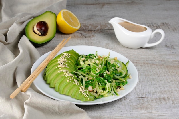 Chukkasalade, komkommernoedels met avocado en pinda-bruine saus in sauskom