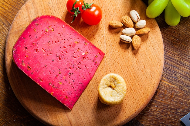 Chunk of red cheese on wooden background.