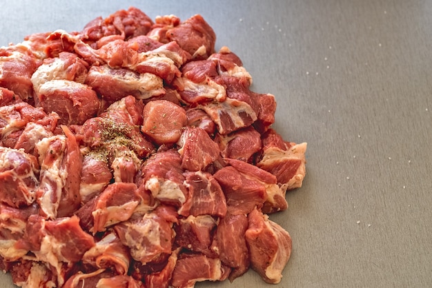 Photo chunks of raw meat on a gray table pork for the grill