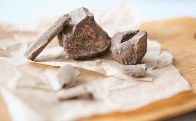 Chunks of roughly crushed chocolate or solid cocoa mass on\
craft paper