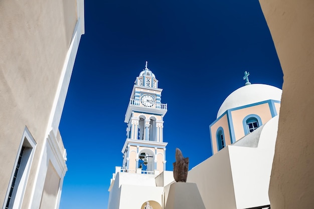 Церковь и колокольня в городе Фира. Белая архитектура на острове Санторини, Греция