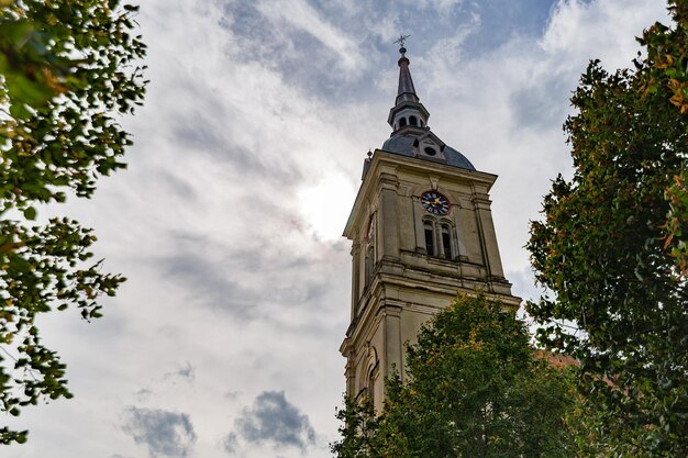 Photo a church bell tower with blue coudy sky