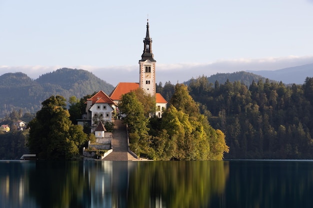 Church in bled lake illuminated from side view at sunrise with clear