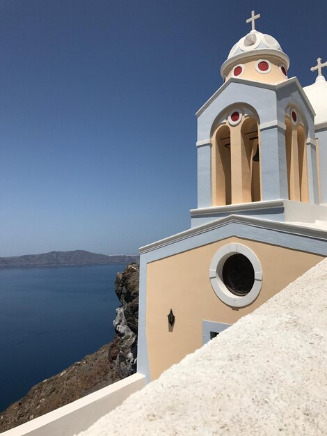 Photo church by sea against clear sky