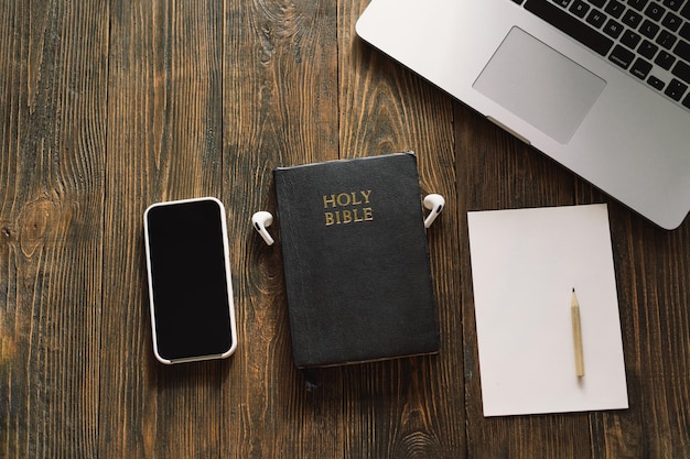 Church online sunday new normal concept bible cell phone and\
earbuds on a wood background