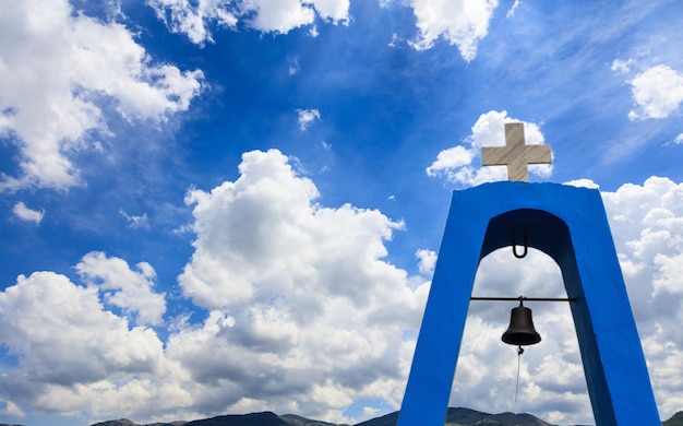 Church's torenspits in Griekenland Kruis op de top en bel Wolken op blauwe hemel achtergrond copyspace