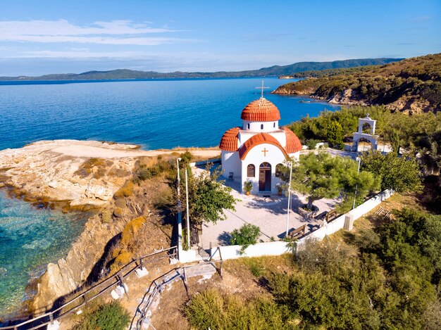 Chiesa e mare con spiaggia e montagne a nea roda, halkidiki, grecia