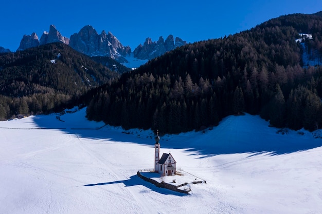 Church of St John Forest and Dolomites on Sunny Winter Day South Tyrol Italy Aerial View