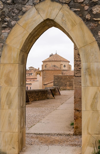 Church view through a gothic door in the wall of Cuenca in Castilla la Mancha, Spain