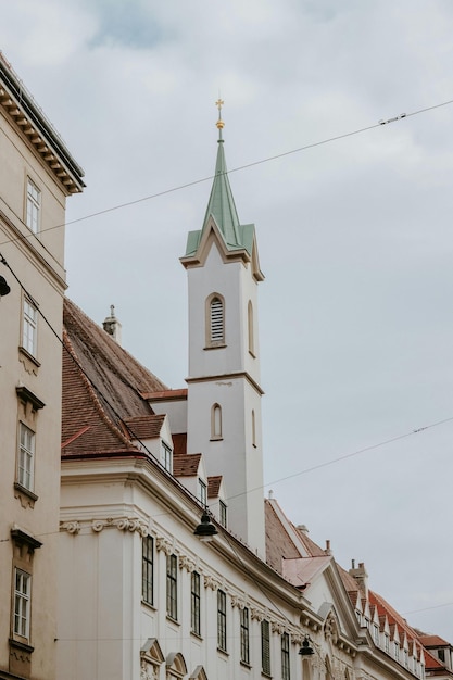 a church with a green steeple and a clock on the top