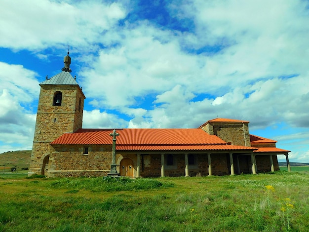 A church with a red roof and a cross on the top.