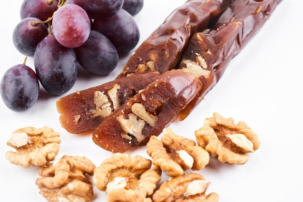 Churchkhela, national Georgian dessert made from grape juice and walnut, isolated composition on white